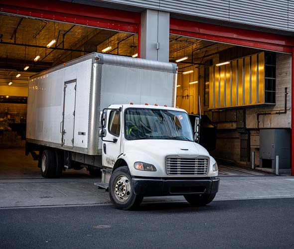 big moving truck backing into city loading dock